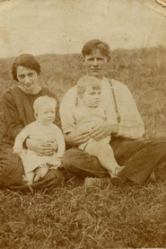 Auf diesem Bild sind Truus’ Mutter und Vater zu sehen. Die Mutter hat die neun Monate alte Truus auf dem Schoß. Der Junge, den der Vater hält, ist vermutlich ein Nachbarskind.